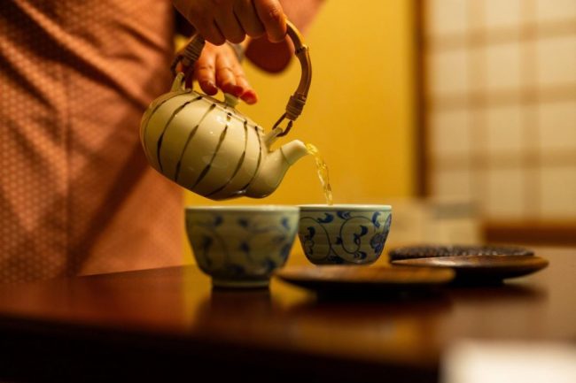 Teekanne und Keramiktassen in warmem Licht in Takayama, Japan